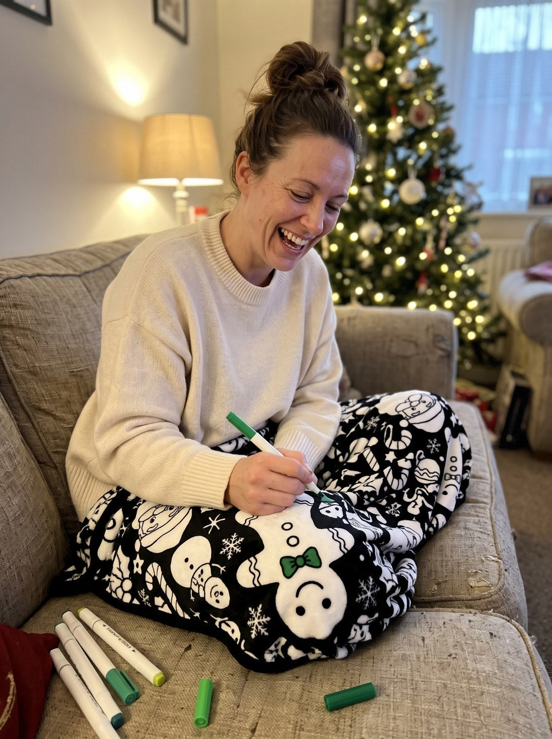 Woman coloring the Christmas blanket on the sofa